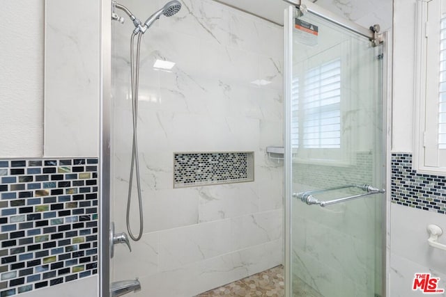 bathroom featuring an enclosed shower and tile walls