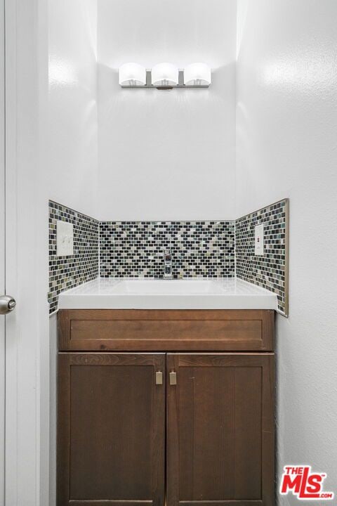 bathroom featuring decorative backsplash and vanity