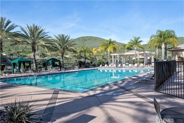 view of swimming pool with a mountain view and a patio