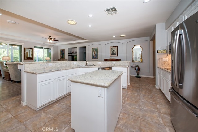 kitchen with appliances with stainless steel finishes, a center island, ceiling fan, and sink