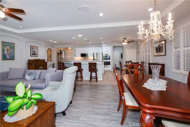 living room featuring ceiling fan with notable chandelier, light wood-type flooring, and crown molding