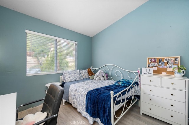 bedroom featuring light hardwood / wood-style floors and lofted ceiling