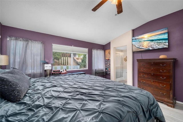 bedroom featuring ensuite bath, ceiling fan, light hardwood / wood-style flooring, and vaulted ceiling