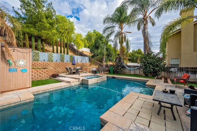 view of pool with an in ground hot tub and a patio