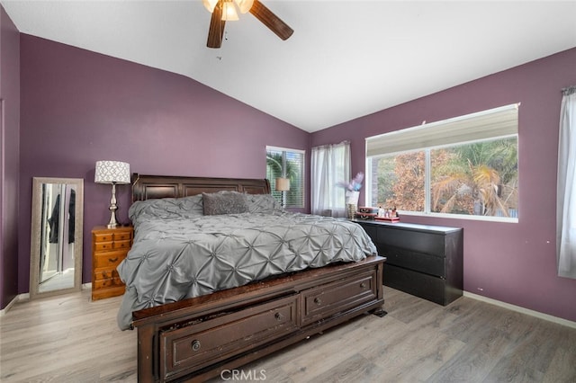 bedroom featuring ceiling fan, light hardwood / wood-style floors, and lofted ceiling