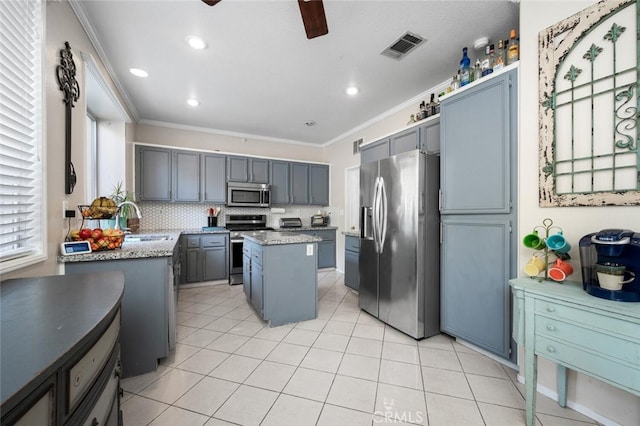 kitchen featuring a center island, stainless steel appliances, crown molding, and sink