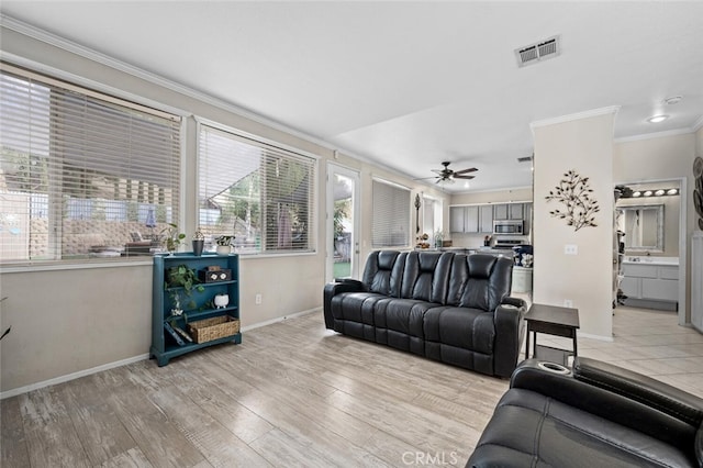 living room featuring ceiling fan, ornamental molding, and light hardwood / wood-style flooring