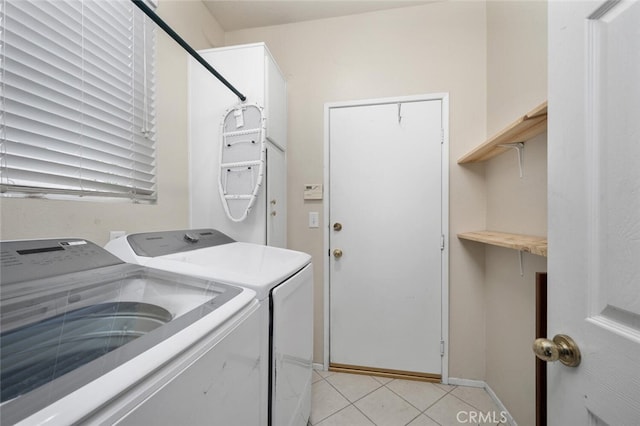 washroom with light tile patterned floors and washing machine and dryer