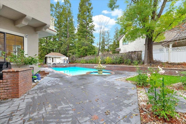 view of pool featuring an outbuilding, a patio, and area for grilling