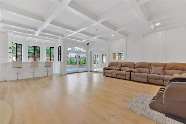 unfurnished living room with plenty of natural light, light hardwood / wood-style flooring, beam ceiling, and coffered ceiling