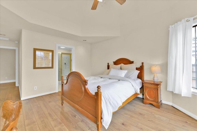 bedroom featuring ceiling fan, light hardwood / wood-style floors, and connected bathroom