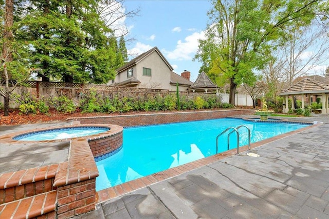 view of pool with a patio area, a gazebo, and an in ground hot tub