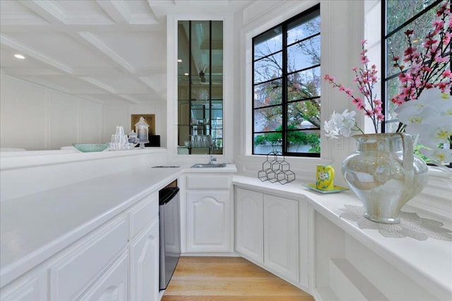 interior space with beamed ceiling, sink, coffered ceiling, light hardwood / wood-style flooring, and white cabinets