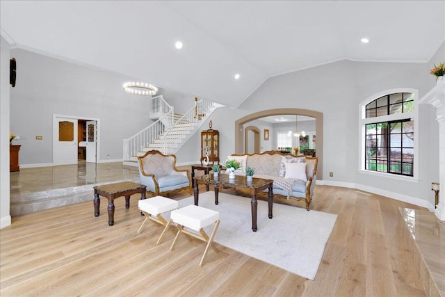 living room featuring lofted ceiling, a chandelier, and light wood-type flooring