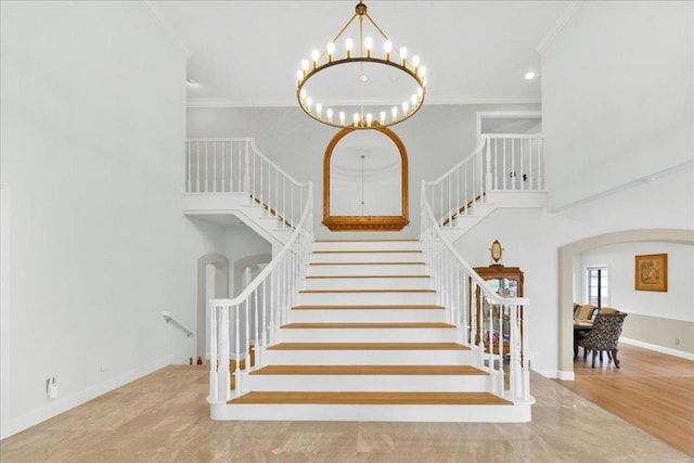 stairway with an inviting chandelier and crown molding