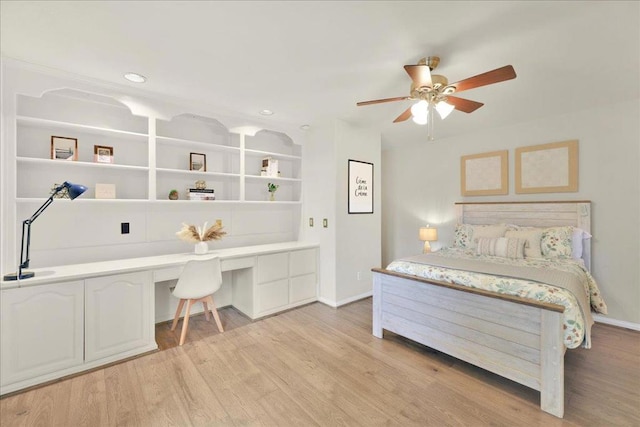 bedroom featuring ceiling fan, built in desk, and light wood-type flooring