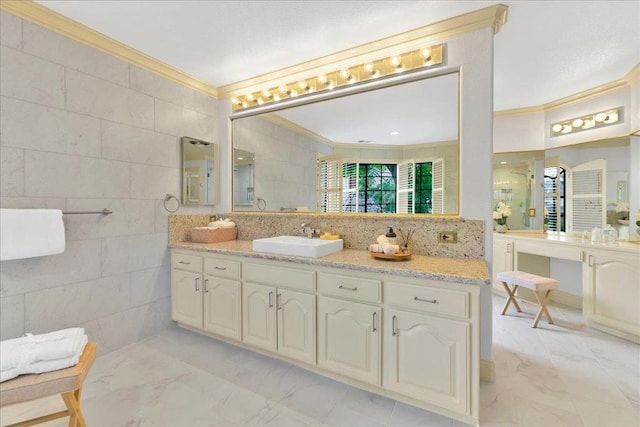 bathroom with tile walls, vanity, ornamental molding, and tasteful backsplash