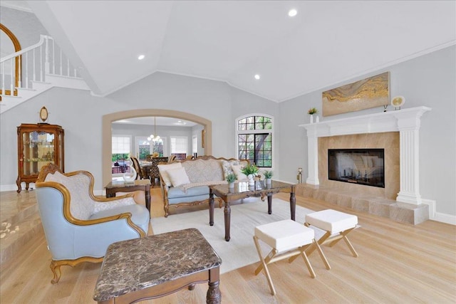 living room with vaulted ceiling, light hardwood / wood-style flooring, and a tiled fireplace