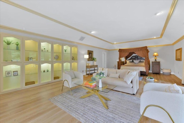 living room featuring light hardwood / wood-style floors, a raised ceiling, and crown molding