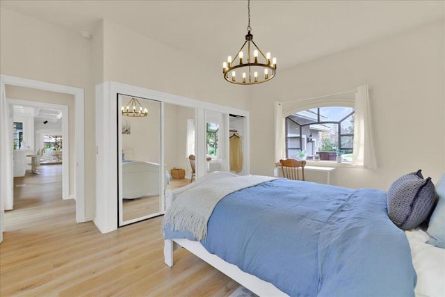 bedroom with an inviting chandelier and light hardwood / wood-style flooring