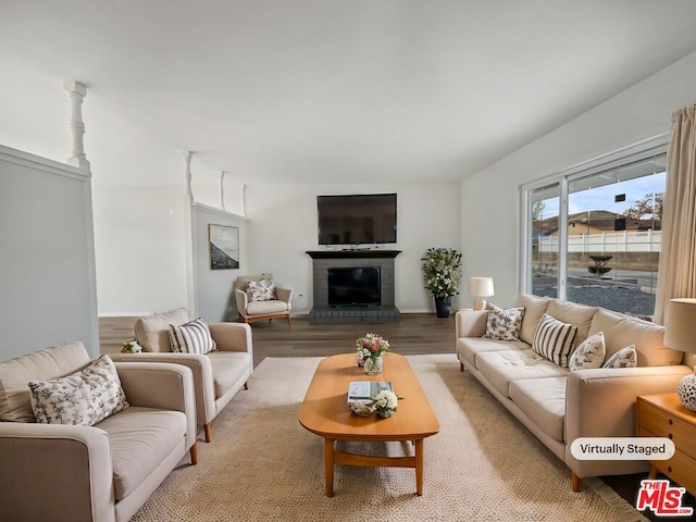 living room with light wood-type flooring and a brick fireplace