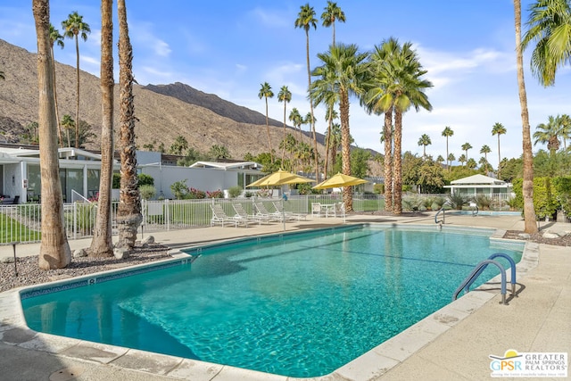 view of swimming pool with a mountain view and a patio