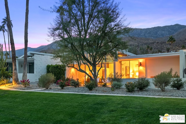 exterior space featuring a lawn and a mountain view