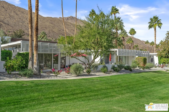 exterior space with a mountain view and a front lawn