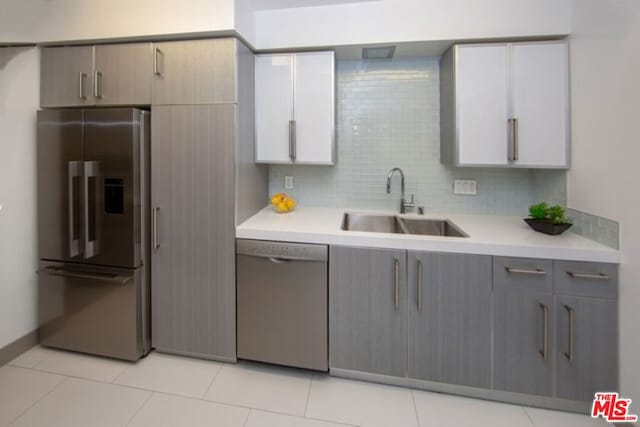 kitchen with tasteful backsplash, gray cabinetry, sink, and appliances with stainless steel finishes