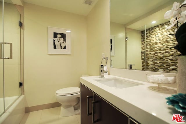 full bathroom with tile patterned floors, vanity, enclosed tub / shower combo, and toilet