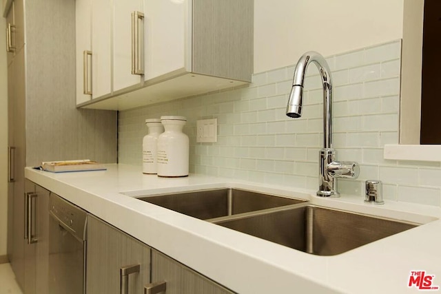 kitchen featuring dishwasher, backsplash, and sink