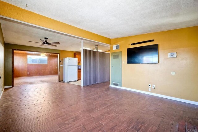 unfurnished living room with ceiling fan and a textured ceiling