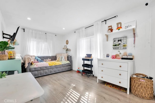 bedroom with light wood-type flooring and multiple windows