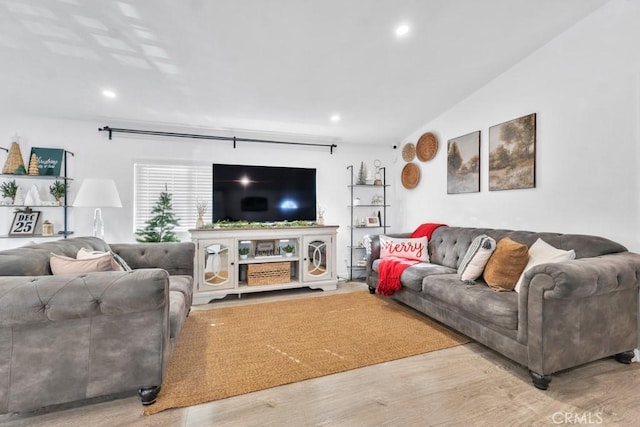 living room featuring hardwood / wood-style flooring and vaulted ceiling