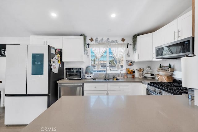 kitchen with stainless steel appliances, white cabinets, and sink