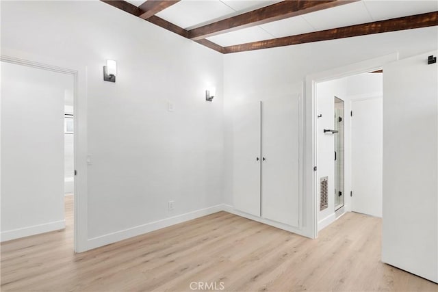 unfurnished room featuring lofted ceiling with beams and light hardwood / wood-style floors