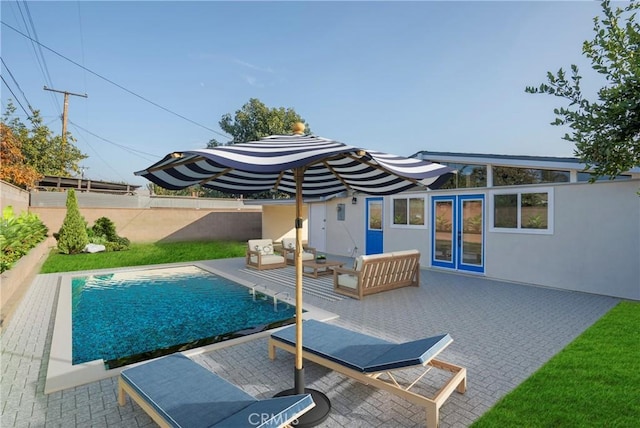 back of house featuring a fenced in pool, outdoor lounge area, french doors, and a patio