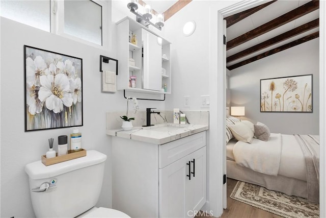 bathroom with vaulted ceiling with beams, vanity, hardwood / wood-style flooring, and toilet