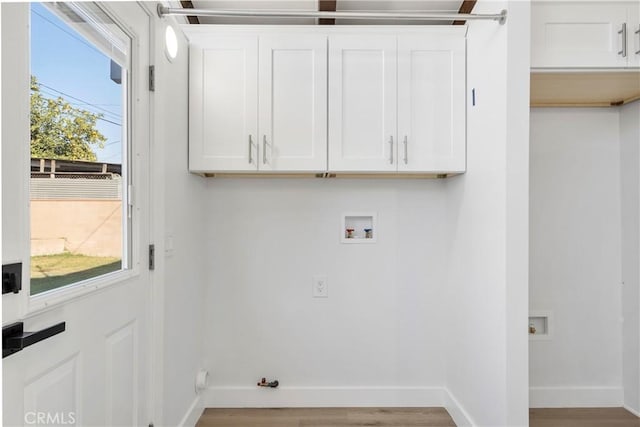 washroom with gas dryer hookup, hookup for a washing machine, cabinets, and light hardwood / wood-style floors