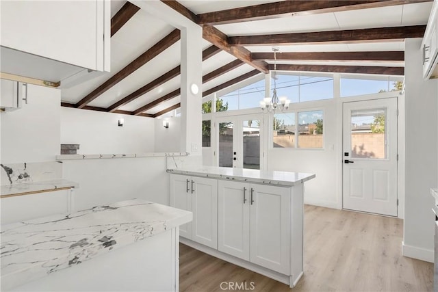 kitchen featuring light stone countertops, french doors, vaulted ceiling with beams, white cabinets, and light wood-type flooring