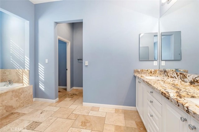 bathroom featuring vanity and tiled bath