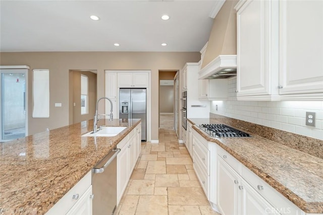 kitchen featuring custom exhaust hood, backsplash, white cabinets, sink, and stainless steel appliances