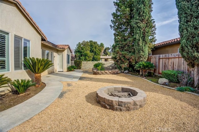 view of yard featuring a fire pit and a patio area