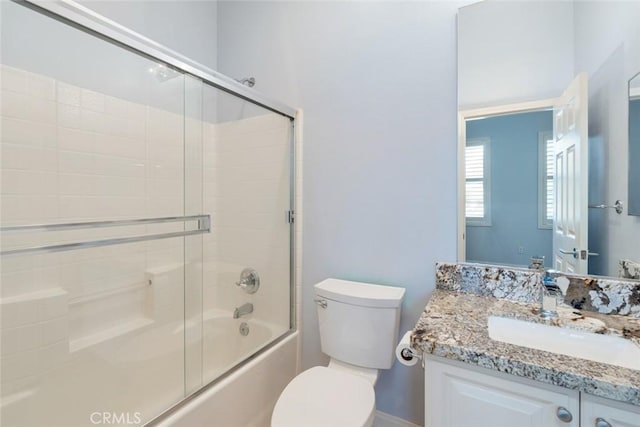 full bathroom with vanity, toilet, and bath / shower combo with glass door