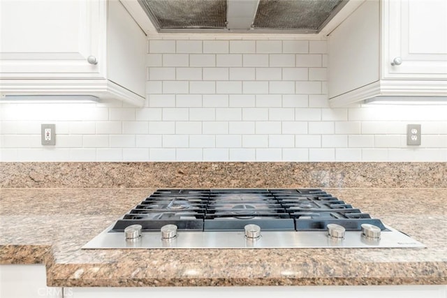 details with extractor fan, decorative backsplash, white cabinetry, and stainless steel gas stovetop