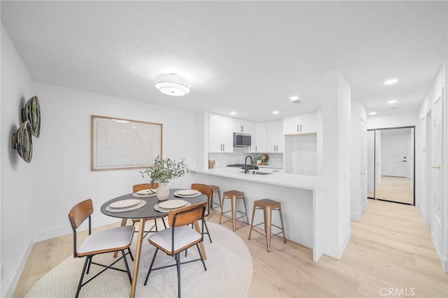 dining area featuring sink and light wood-type flooring