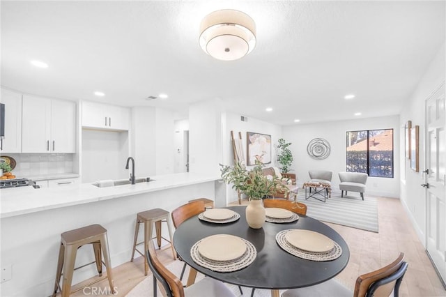 dining room with light wood-type flooring and sink