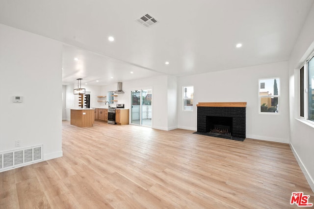 unfurnished living room with light wood-type flooring and a fireplace