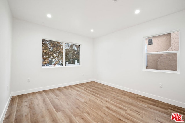 empty room with light hardwood / wood-style flooring