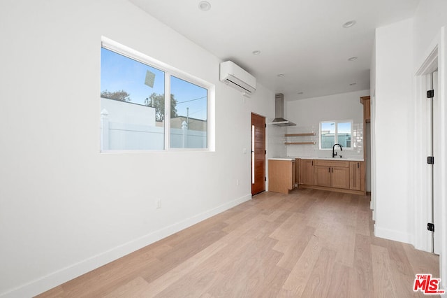 interior space with light hardwood / wood-style flooring, an AC wall unit, plenty of natural light, and sink